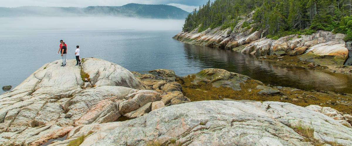Tadoussac showing a lake or waterhole as well as a small group of people