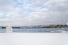 Snow covered winter view of the boat dock and swim area of Honeysuckle beach on Hayden Lake, in Hayden Lake, Idaho, USA