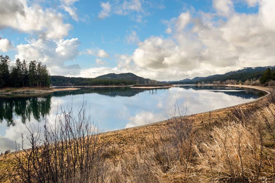 Un lago tranquilo rodeado de colinas y árboles.