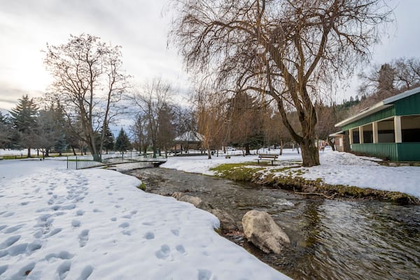 A small creek runs through the small public park with snow during winter at Rathdrum, Idaho USA.