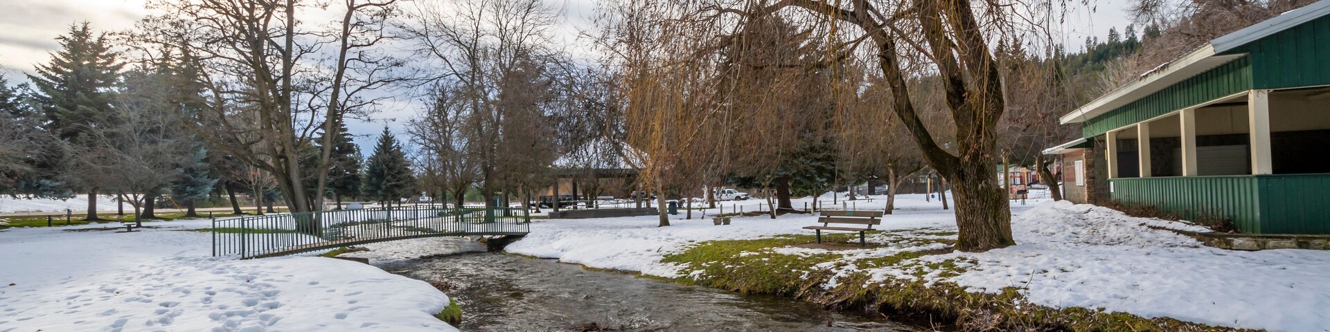 A small creek runs through the small public park with snow during winter at Rathdrum, Idaho USA.