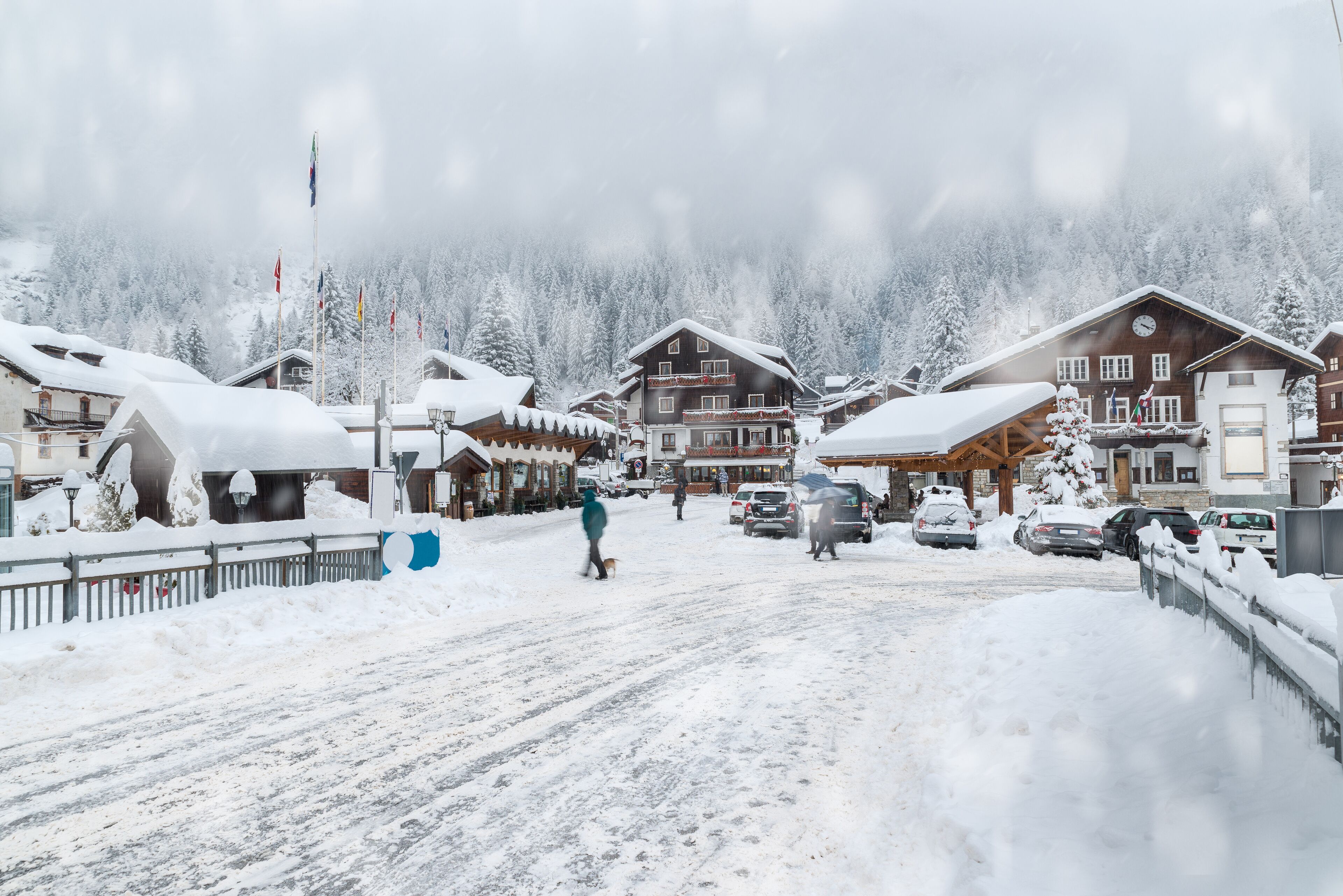 Alpine village under the snow. Macugnaga, Italy, an important winter ski resort at the foot of Monte Rosa, Main square in the center of the village with the town hall on the right during the Christmas