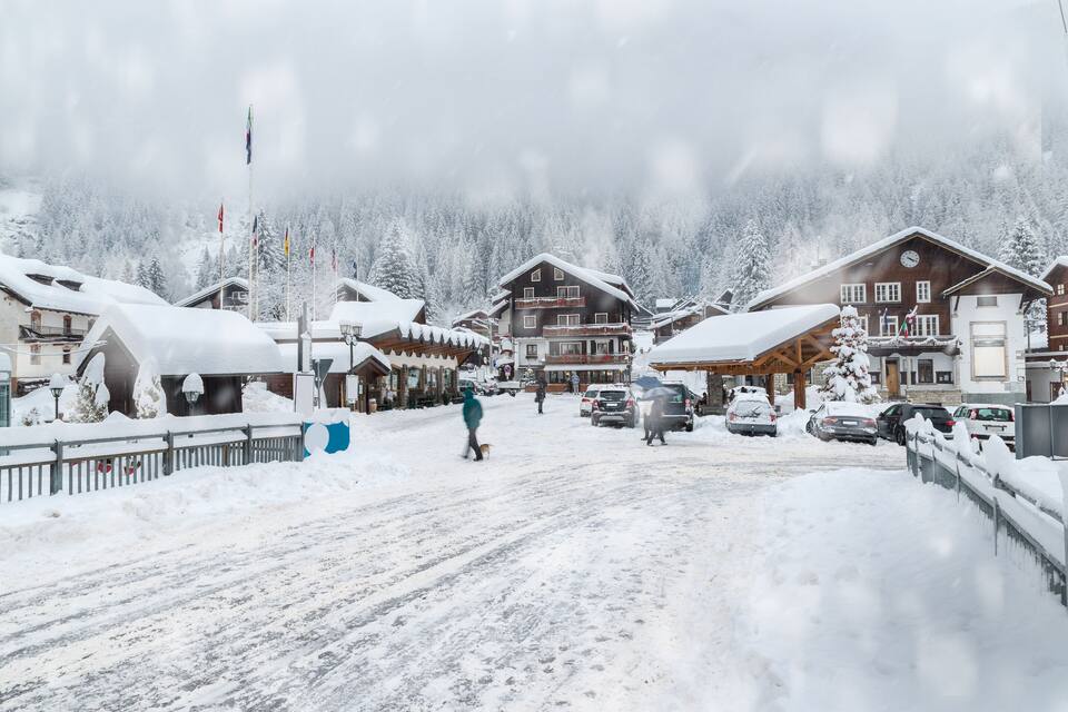 A snowy village with wooden buildings and a snow-covered road.