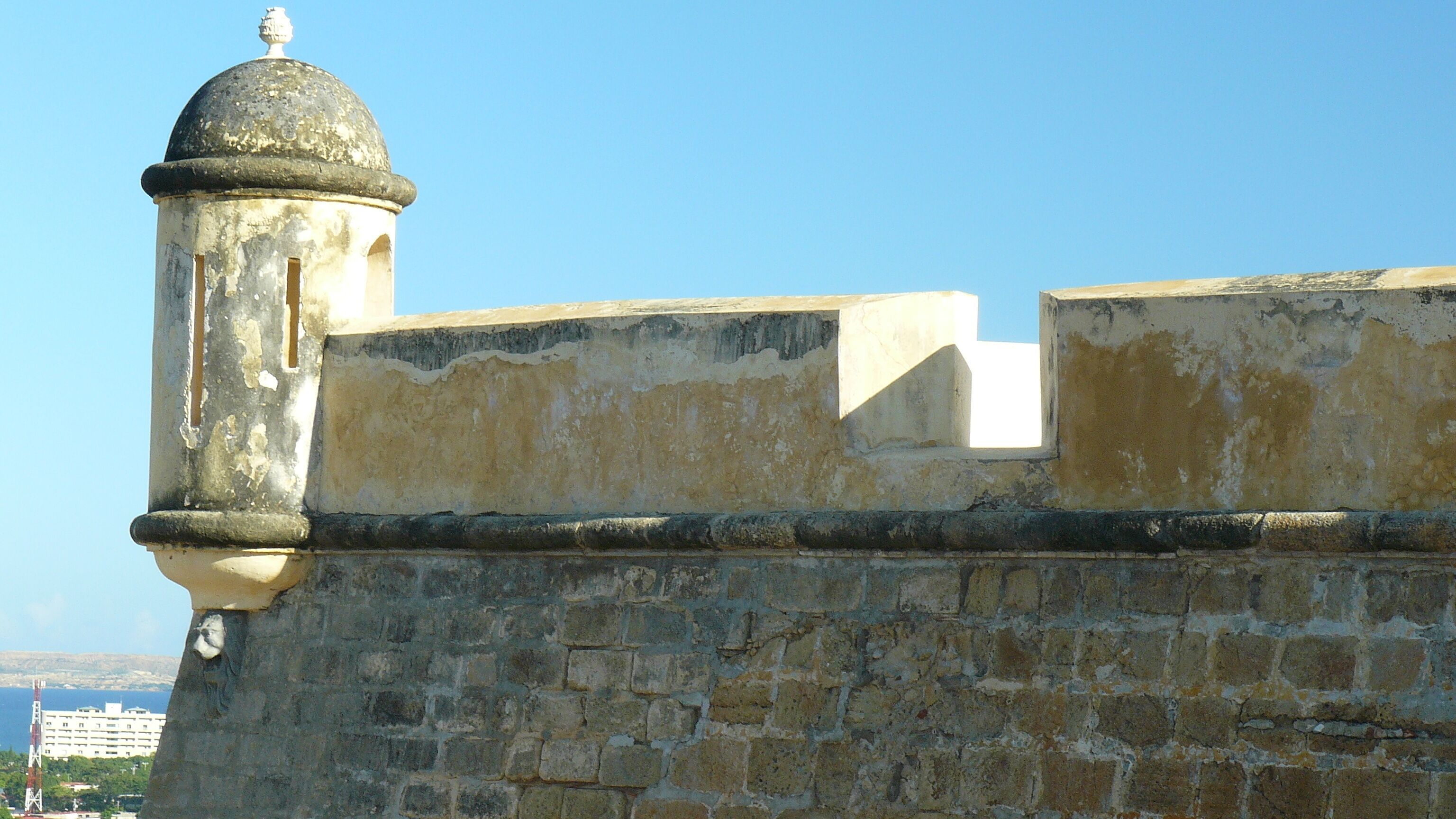 A weathered stone wall with a dome-topped structure.