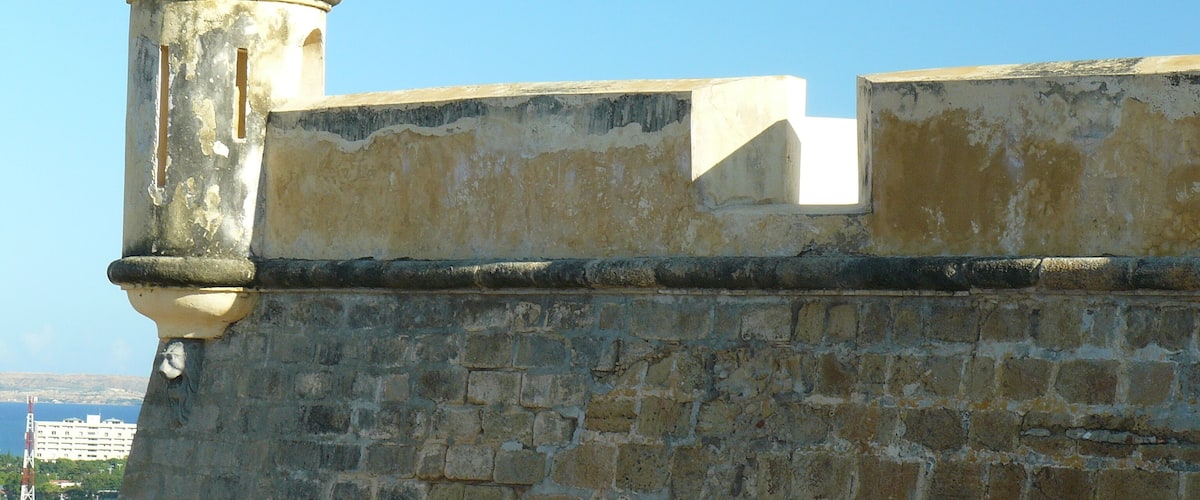A weathered stone wall with a dome-topped structure.