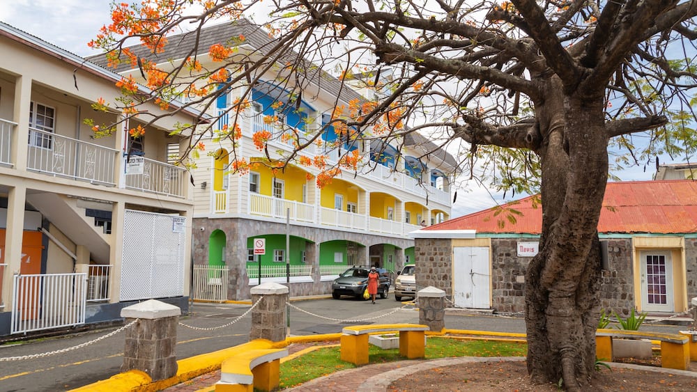 A colorful building with balconies, a tree in the foreground, and a 'No Entry' sign.