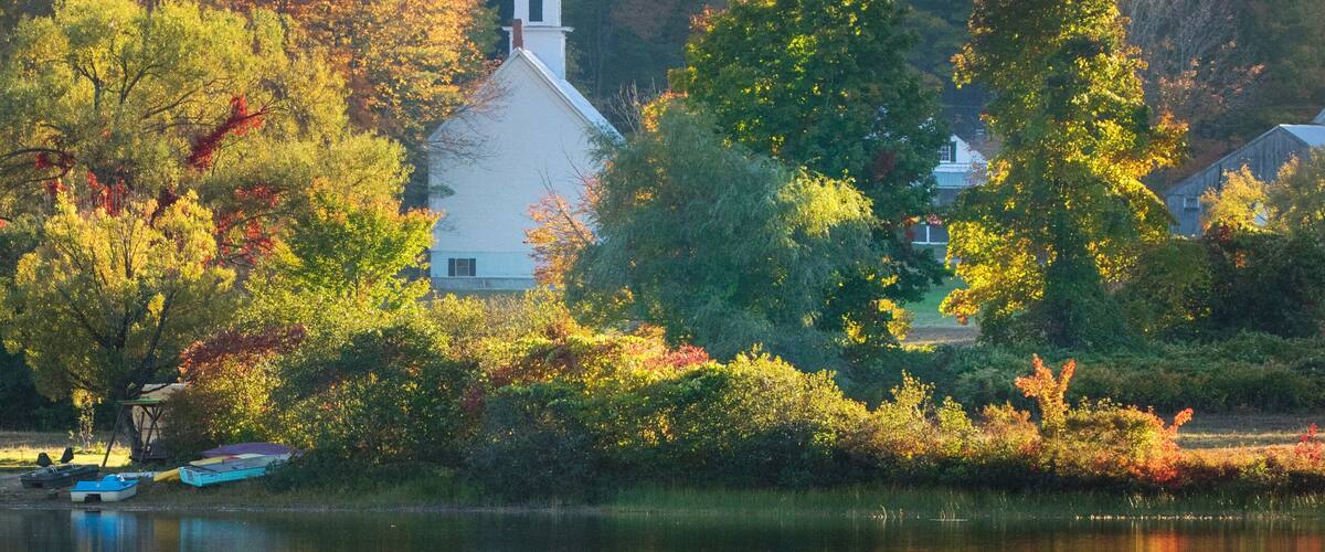 little church reflected in a pond in new england