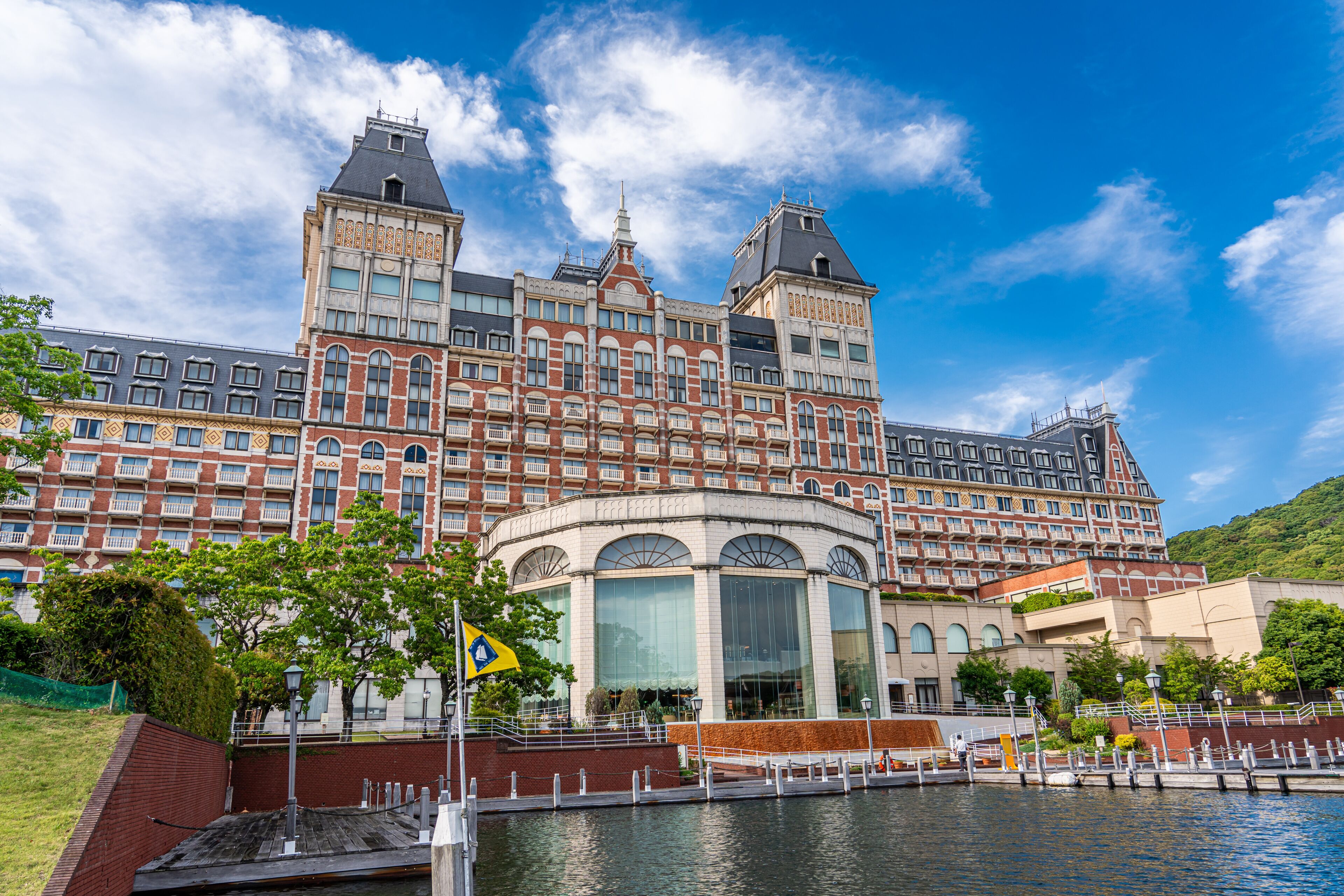 A large, historic building with a prominent tower and a waterfront.