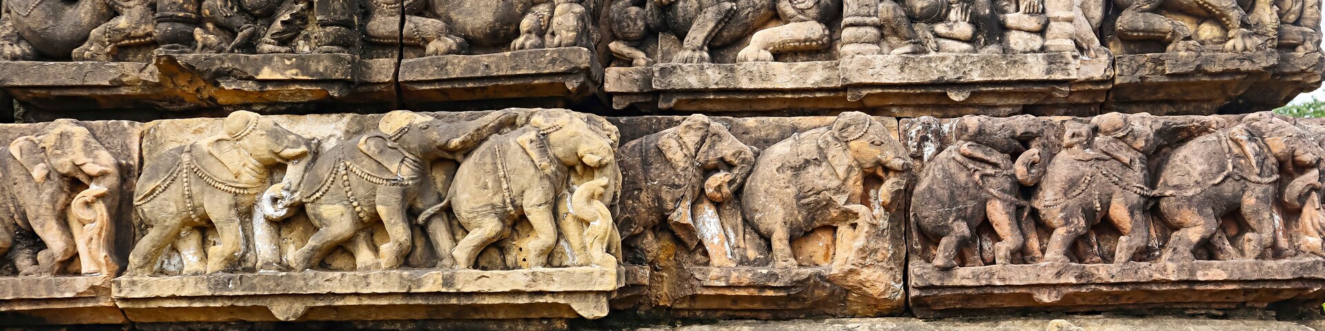 Detailed stone carvings of mythological figures and animals on a temple wall.