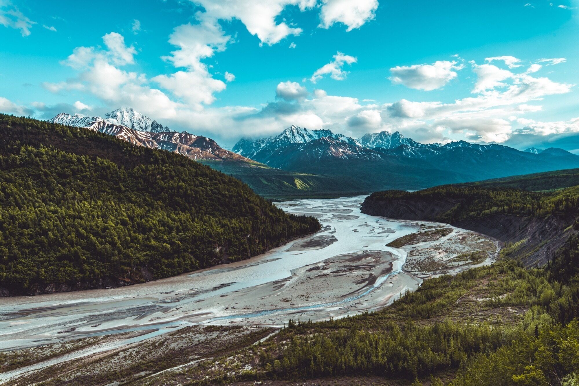 A river winding through a valley with mountains in the background.