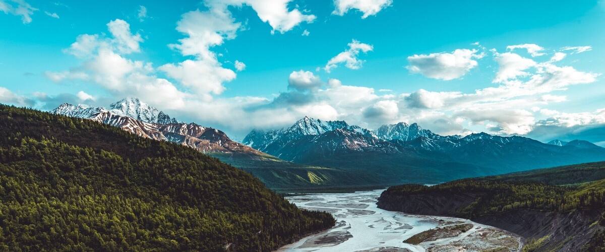 A river winding through a valley with mountains in the background.