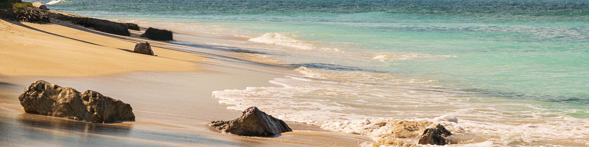 Beautiful sandy beach and crystal clear turquoise sea water in perfect tropical caribbean vacation destination. La Playita beach in Las Galeras, Dominican Republic.