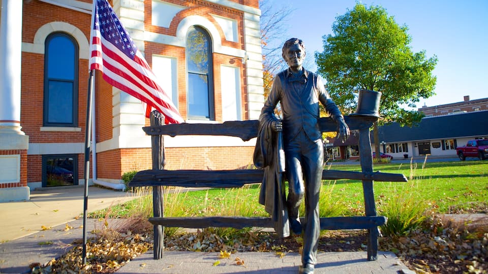 A statue of a man with a rifle, an American flag, and a building with arched windows.
