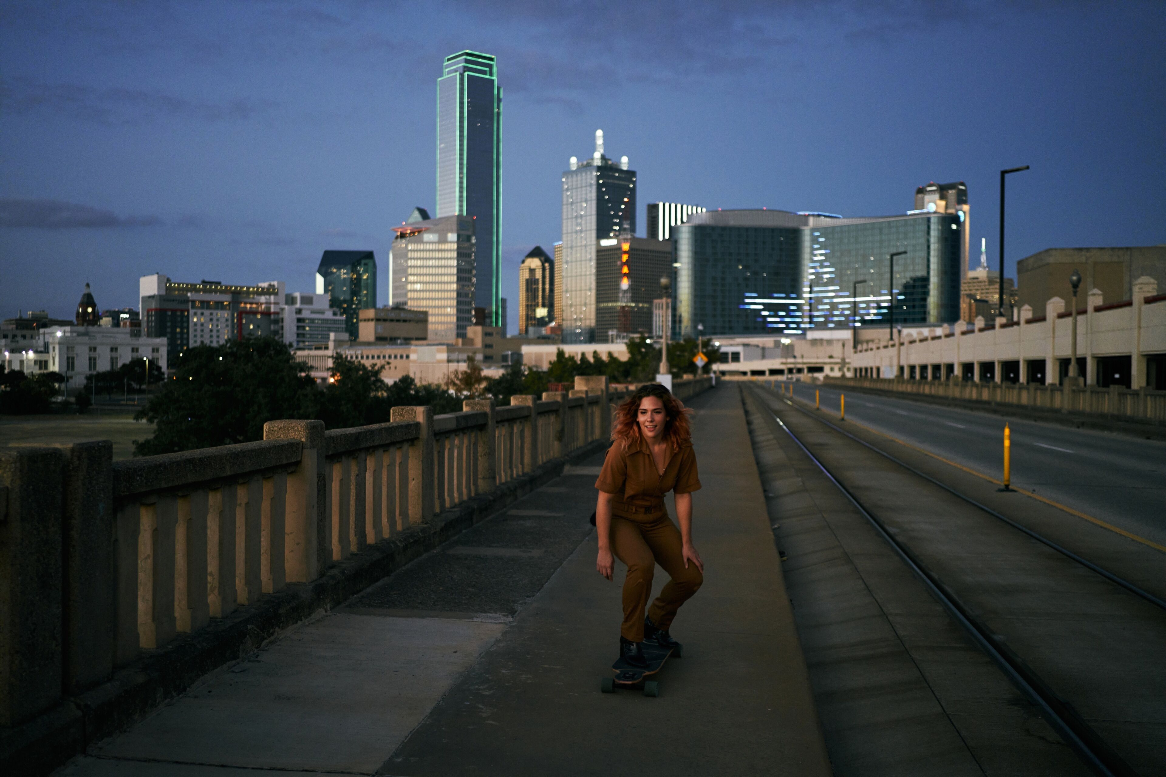Young american girl skating at dusk in Dallas streets