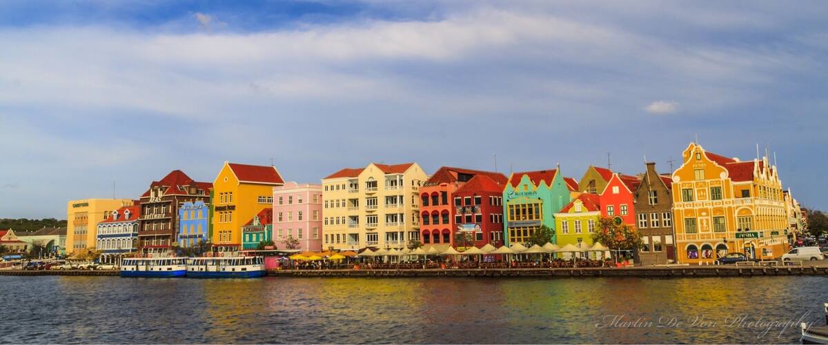 A waterfront with colorful buildings and a boat.