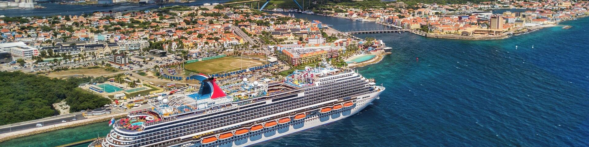 Drone shot hovering off the coast of Willemstad with the Carnival Horizon in Port