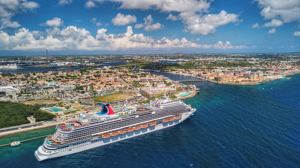 Drone shot hovering off the coast of Willemstad with the Carnival Horizon in Port
