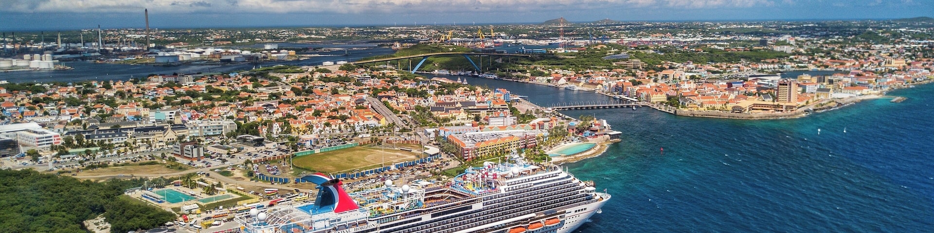 Drone shot hovering off the coast of Willemstad with the Carnival Horizon in Port