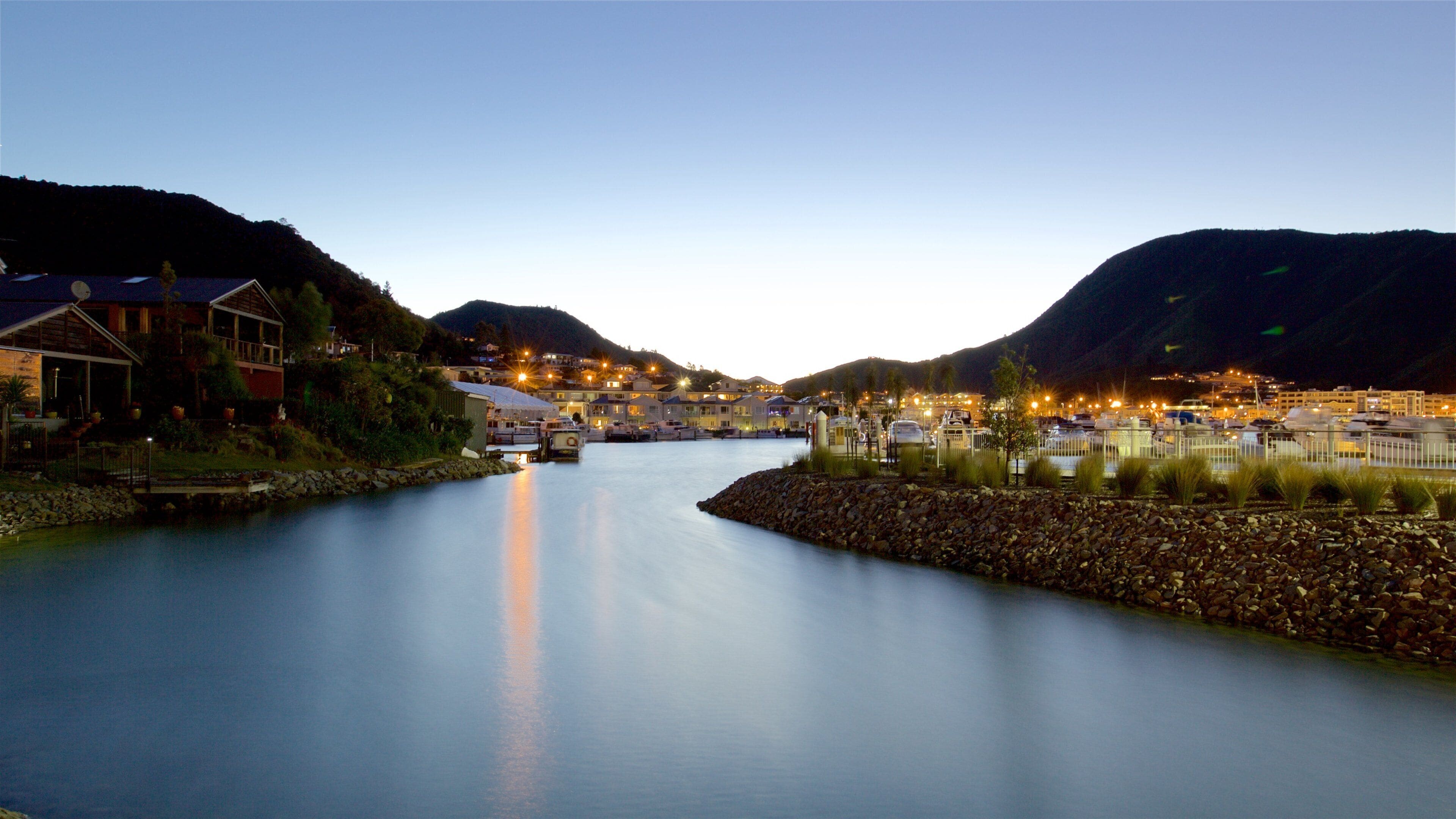 Picton que incluye una bahía o puerto, montañas y una puesta de sol