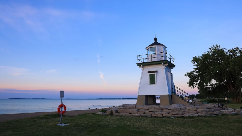 A lighthouse by the water at dusk.