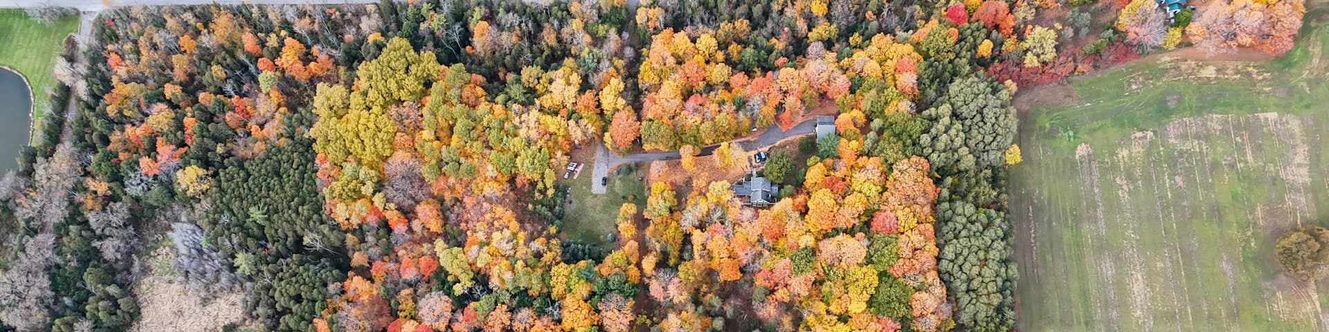 Stunning aerial view of colorful autumn forest with houses and farmland, Port Hope, Ontario, Canada
