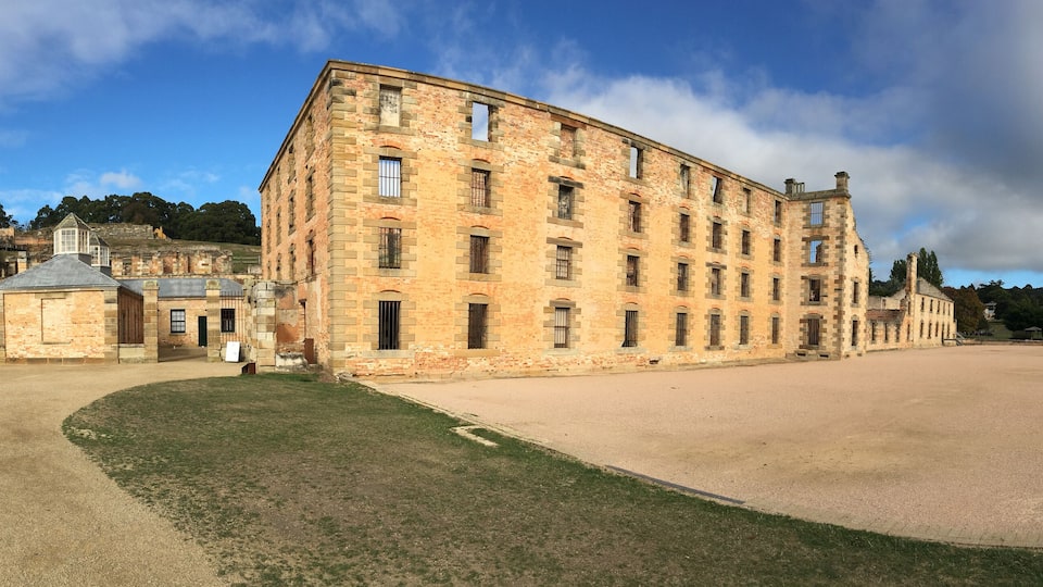 A historic stone building with a large courtyard, surrounded by a park and other historic structures.