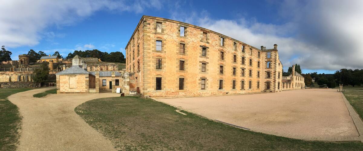 A historic stone building with a large courtyard, surrounded by a park and other historic structures.