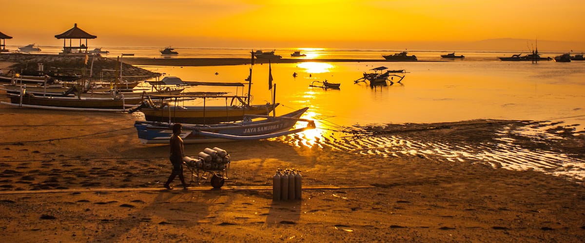 Traditional Balinese boats and pavilion in Sanur beach in the morning at dawn, Bali, Indonesia.