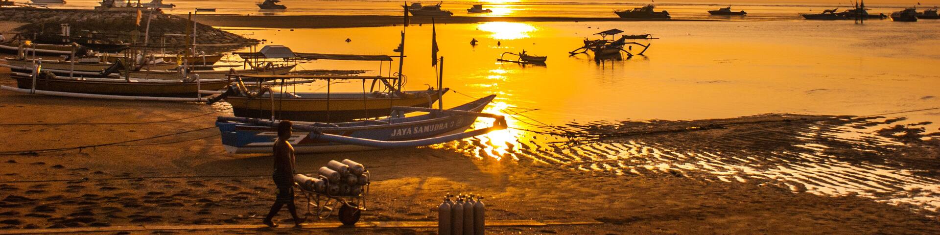 Traditional Balinese boats and pavilion in Sanur beach in the morning at dawn, Bali, Indonesia.