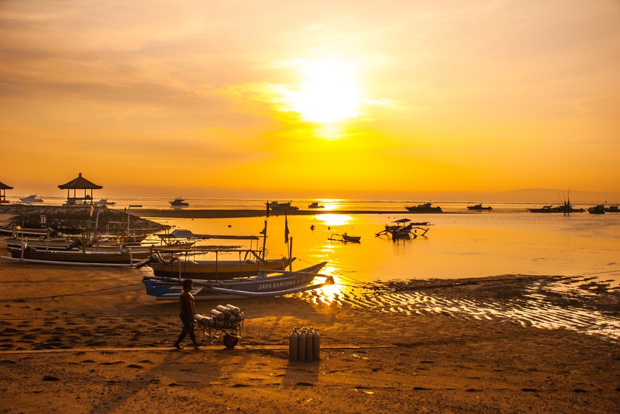Traditional Balinese boats and pavilion in Sanur beach in the morning at dawn, Bali, Indonesia.