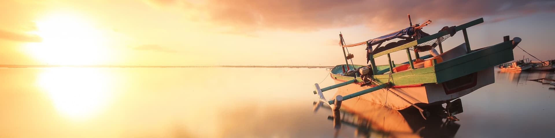 Traditional fisihing boats (outrigger canoes) moored off Bali's Tuban Beach, Indonesia.