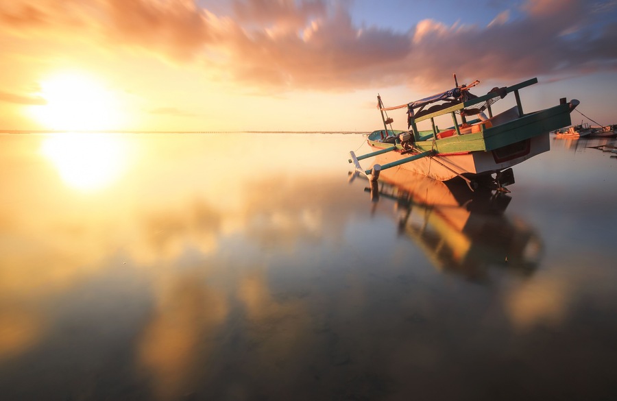 Traditional fisihing boats (outrigger canoes) moored off Bali's Tuban Beach, Indonesia.