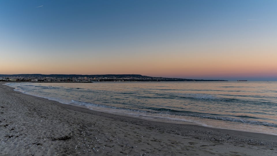 panorama landscape of Asparuhovo Beach at sunset and the Bulgarian Black Sea city of Varna in the background