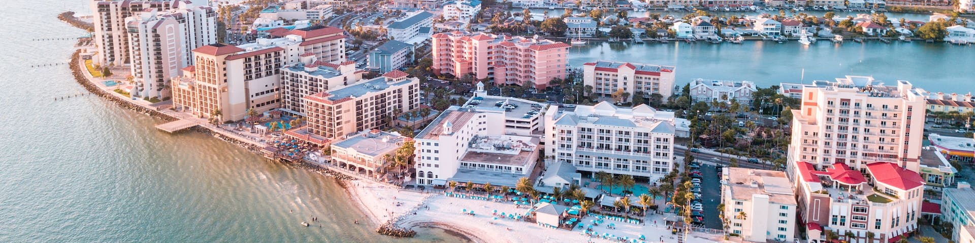 Panorama of city Clearwater Beach FL. Summer vacations in Florida. Beautiful View on Hotels and Resorts on Island. Blue color of Ocean water. American Coast or shore Gulf of Mexico. Sky after Sunset.