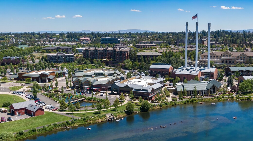 Aerial view of people enjoying the Deschutes River, with Old Mill District in the background. Summer fun on the water. Bend, Oregon, USA