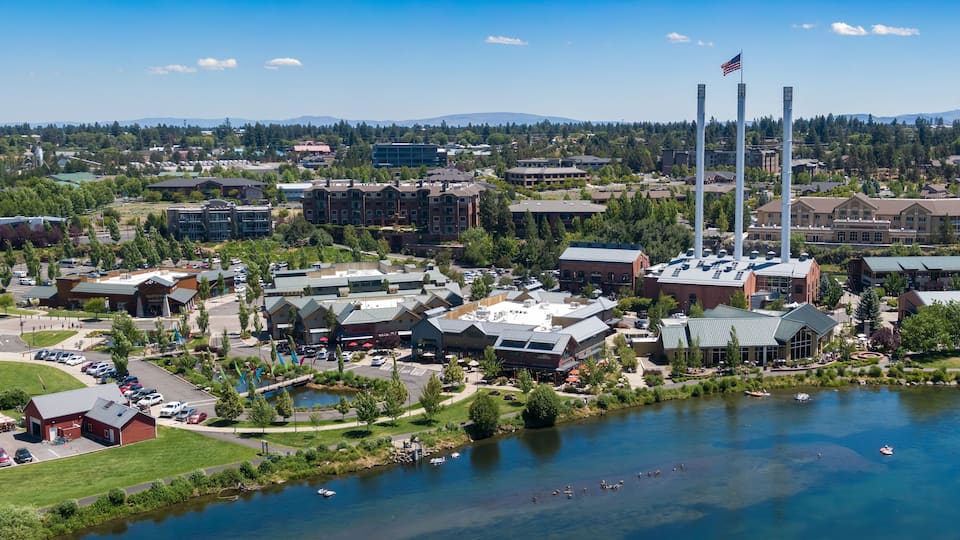 Aerial view of people enjoying the Deschutes River, with Old Mill District in the background. Summer fun on the water. Bend, Oregon, USA