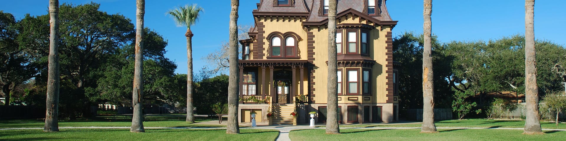 The mansion and palm trees look like a winter retreat.