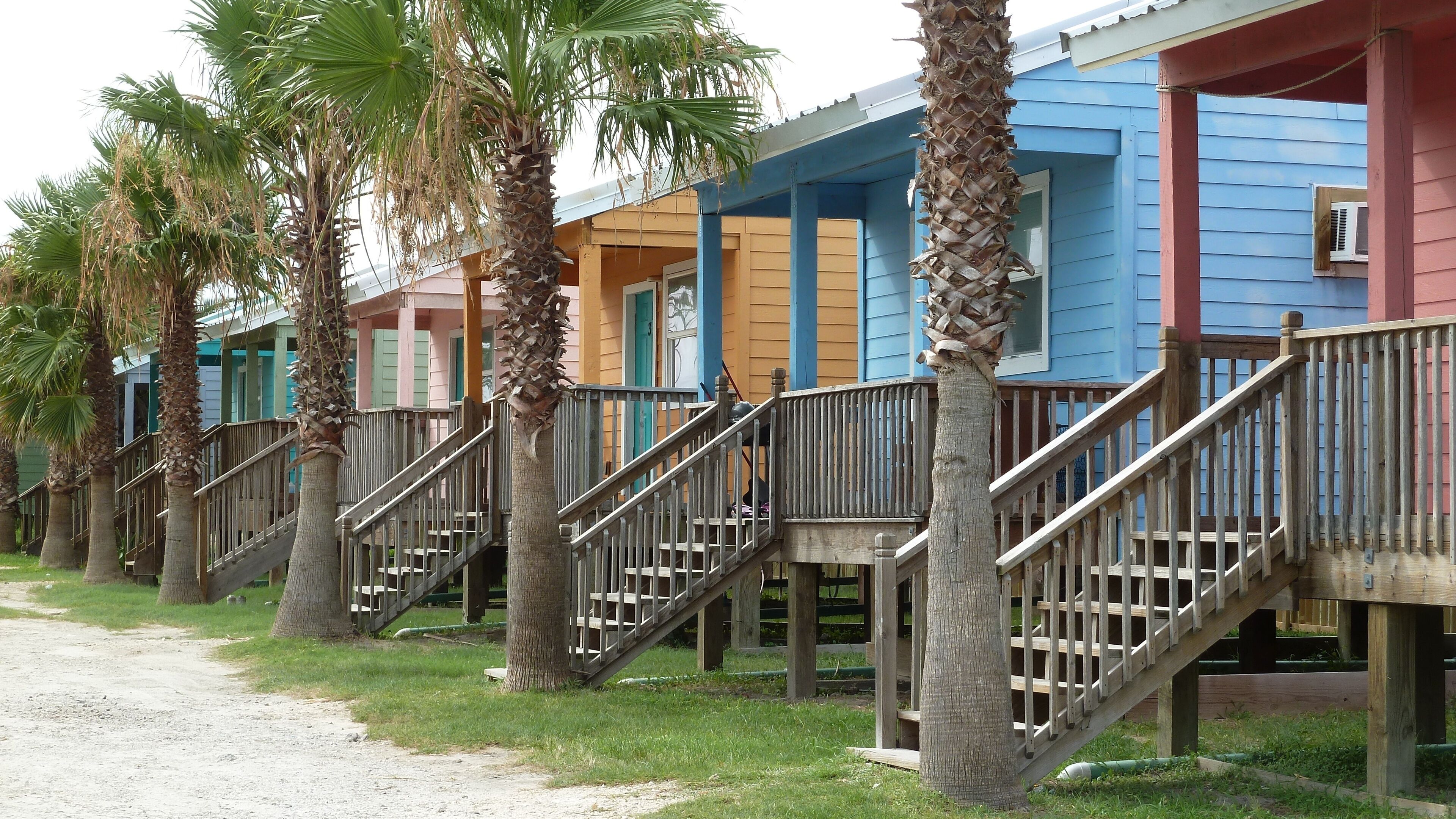 Row of small colorful wooden tiny beach houses and palm trees, Gulf of Mexico