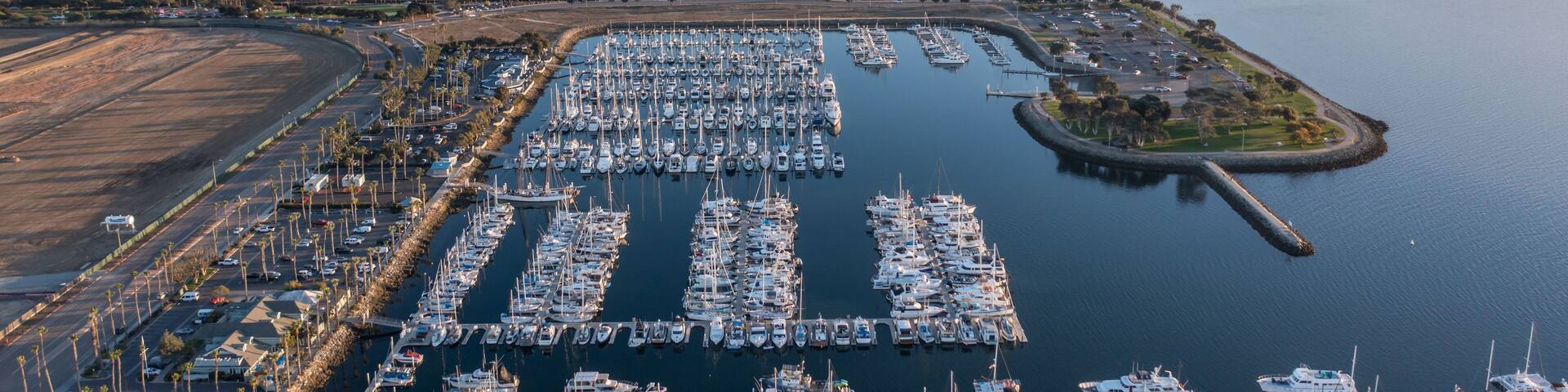 An aerial view of a marina with numerous boats docked in a large, organized harbor.