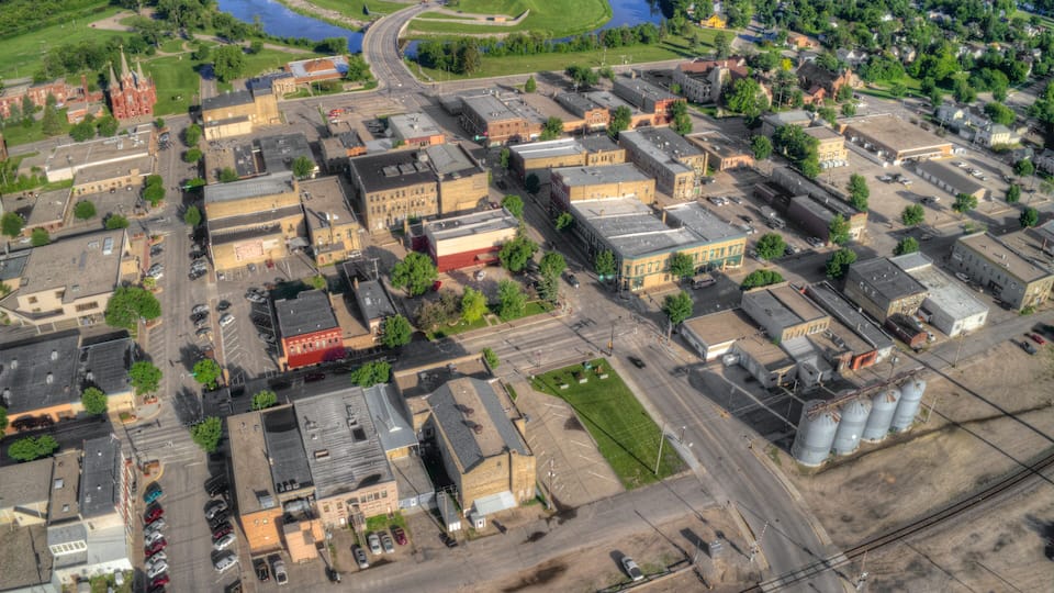 An aerial view of a town with a river, industrial buildings, and a church.