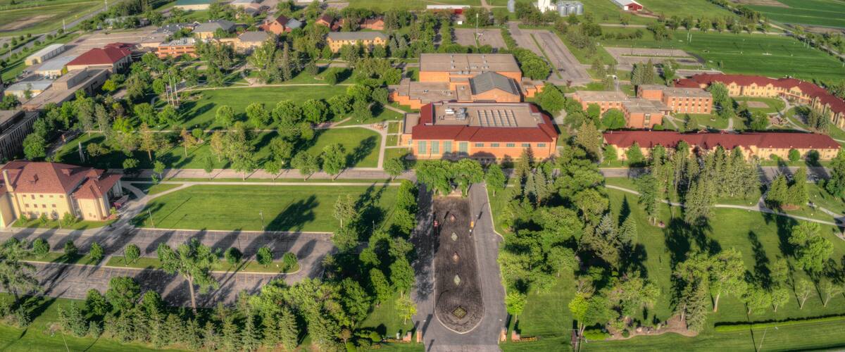 An aerial view of a campus with buildings, roads, and surrounding fields.