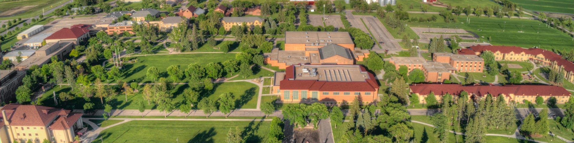 An aerial view of a campus with buildings, roads, and surrounding fields.