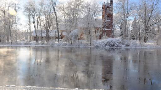 Stone Church with reflection along the river in winter, Potsdam, New York, USA