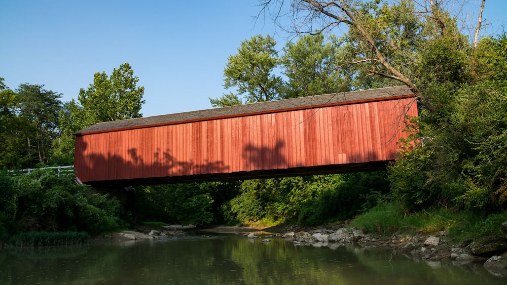 The "Red Covered Bridge" extending over the water on a Summer afternoon. Princeton, Illinois, USA
