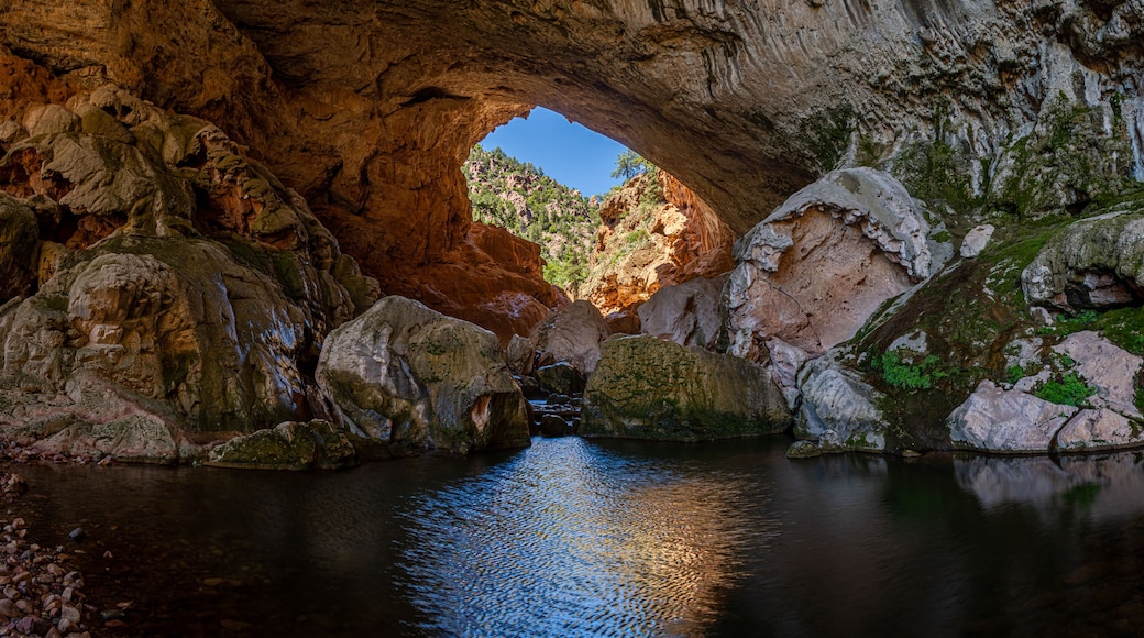 Inside Tonto Natural Bridge in the mountains of Arizona looking at the pond inside of the bridge.