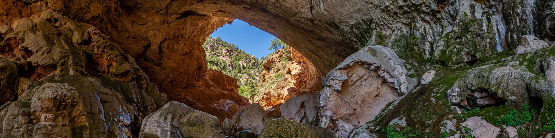 Inside Tonto Natural Bridge in the mountains of Arizona looking at the pond inside of the bridge.