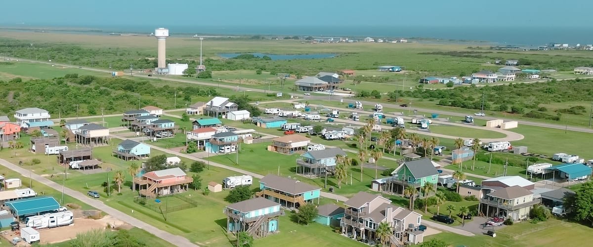 A coastal town with houses, RVs, and a prominent water tower.