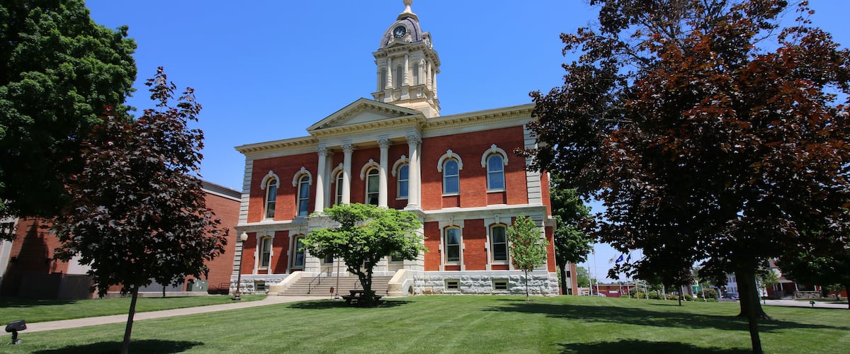 A red brick building with a clock tower and columns.