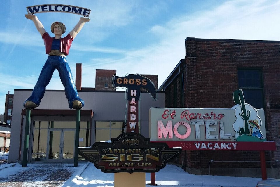 Ein altmodisches amerikanisches Schild, ein 'Welcome'-Schild und ein Schild eines Motels.