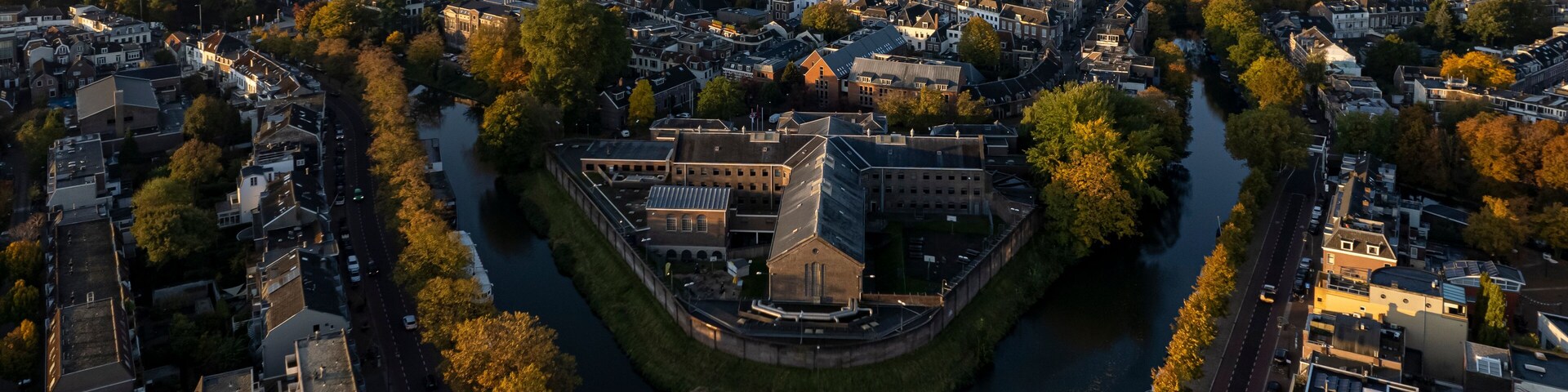 Cityscape skyline of medieval city Utrecht in The Netherlands with De Lik former prison for women in the foreground in autumn sunrise